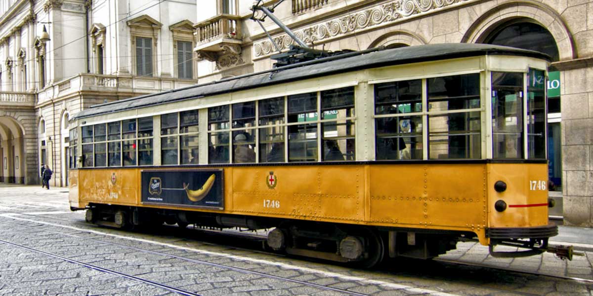 La foto scattata nella città di Milano rappresenta un Tram della linea ATM che passa tra le vie del centro storico della città di Milano